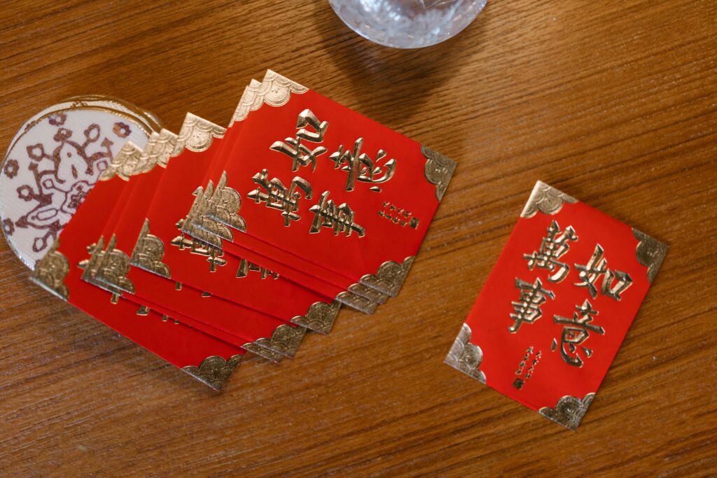 A collection of traditional red envelopes for Chinese New Year on a wooden surface.