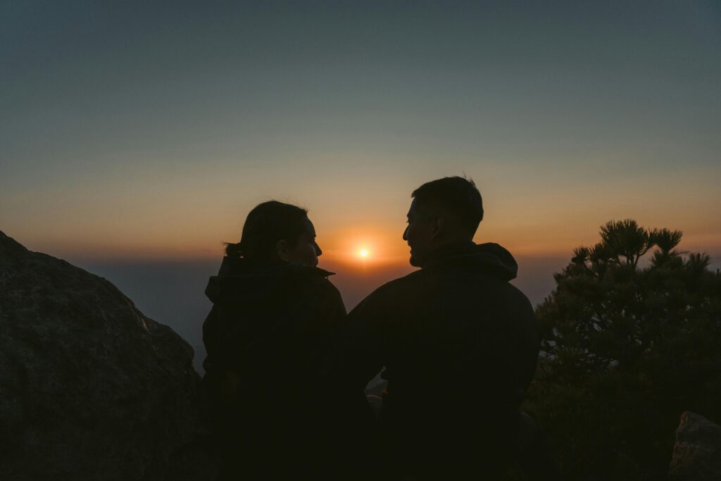 A couple enjoys a scenic sunset view from a rocky hilltop in Ciudad de México.