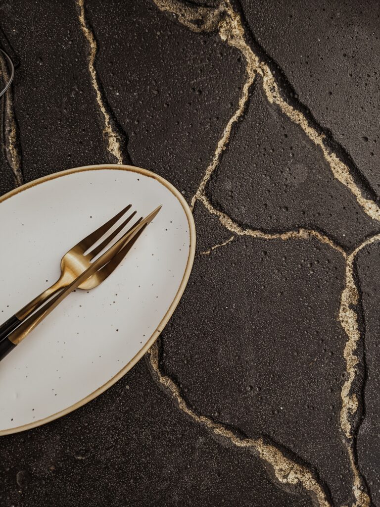 An elegant arrangement of a fork and plate on a textured surface, perfect for culinary themes.
